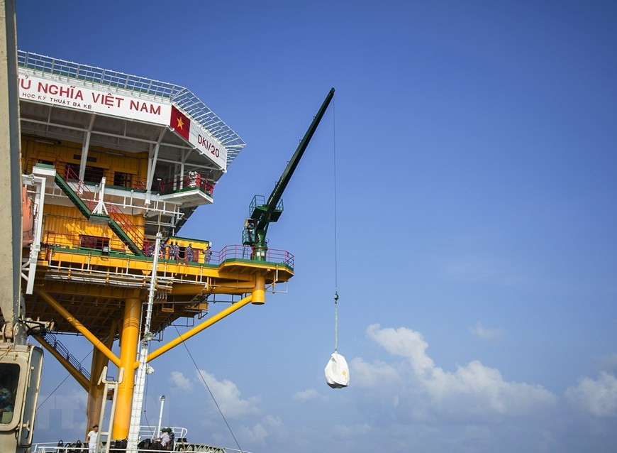 La délégation du Commandement de la 2e zone navale doit utiliser une grue pour livrer des cadeaux. Photo: VNA