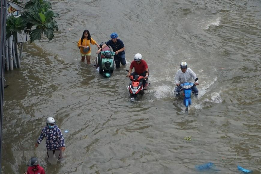  La rue Tran Xuan Soan inondée, ce qui a affecté les déplacements des personnes.