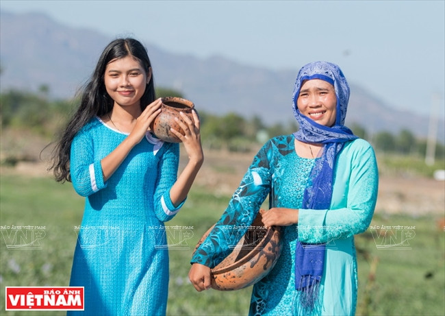  Des femmes de l’ethnie Cham à côté de poteries Go. 