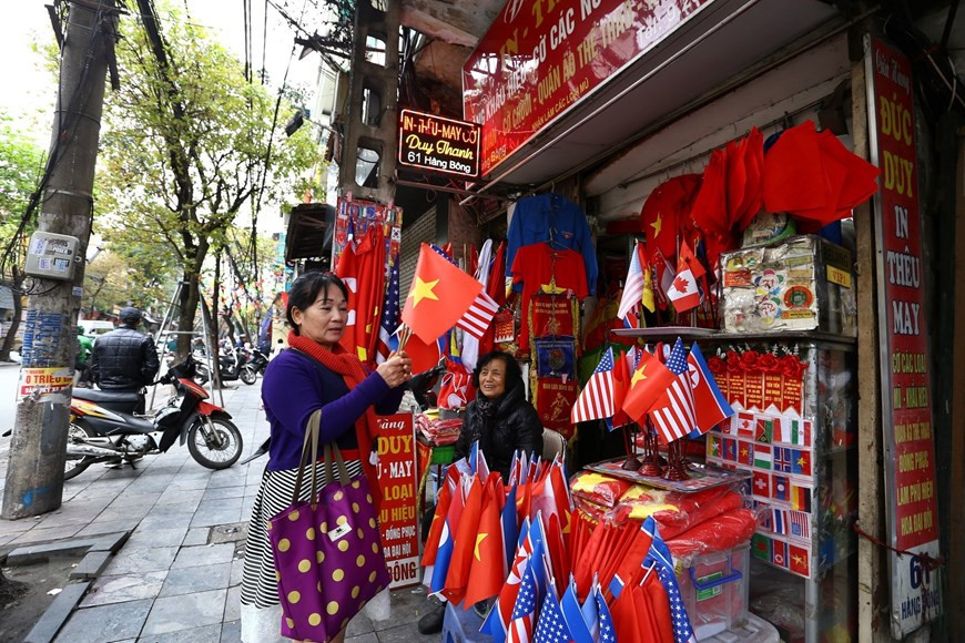  Les touristes achètent des drapeaux des Etats-Unis, de la RPDC et du Vietnam dans la rue Hang Bong.