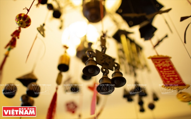  Sa chambre est décorée de cloches de diverses formes, accrochées aux murs ou disposées avec soin dans une vitrine.