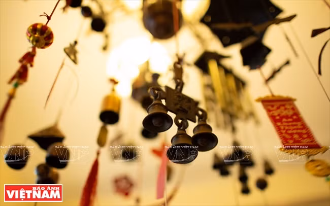  Sa chambre est décorée de cloches de diverses formes, accrochées aux murs ou disposées avec soin dans une vitrine. 