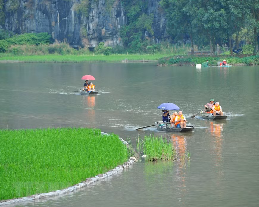  Les touristes étrangers font une belle balade en bateau à Tam Coc. 