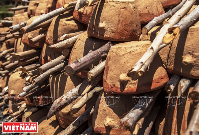  Dans le four, les poteries sont placées en rang en alternance avec du bois.