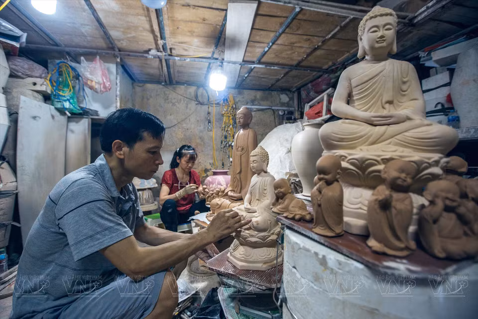 Pham Minh Quang a 34 ans d'expériences dans la peinture de lotus sur la poterie et la sculpture de Bouddha.