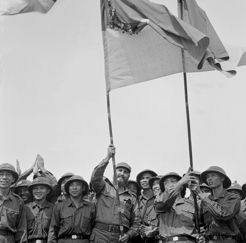 Le Premier secrétaire du PCC et Premier ministre de la République de Cuba, Fidel Castro, brandit le drapeau traditionnel du bataillon de Khe Sanh, de l'Armée de libération de Quang Tri - Huê, au sommet de la colline 241 Tan Lam (Quang Tri, 15 septembre 1973).