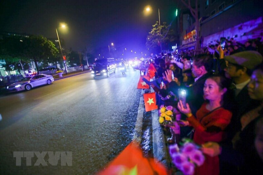 Les habitants de Hanoi avec des drapeaux et des fleurs dans la main sont heureux d’accueillir le président américain Donald Trump. Photo : VNA