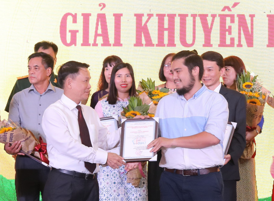 Nguyen Duc Loi, directeur général de l'Agence vietnamienne d'Information (gauche) remet le prix d'encouragement 