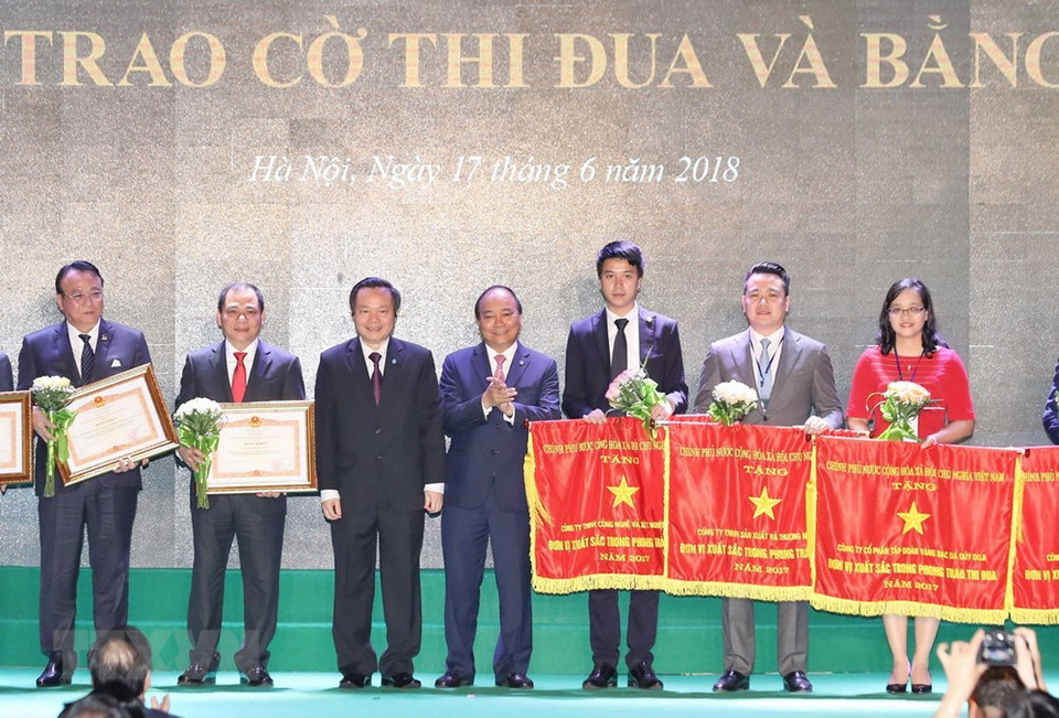 Le Premier ministre Nguyen Xuan Phuc et les représentants des entreprises ayant eu des contributions importantes au développement de Hanoï