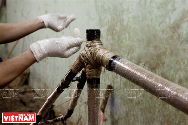 L'artisan qui roule le fil autour des joints.