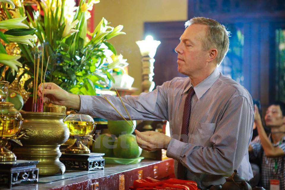 L'ambassadeur américain dépose des bâtonnets d'encens sur l'autel.