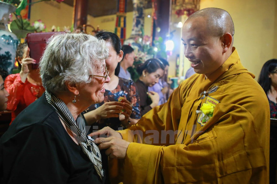 Le bonze Thich Thanh Nhieu met une rose blanche sur le vêtement de la mère de l'ambassadeur Ted Osius.