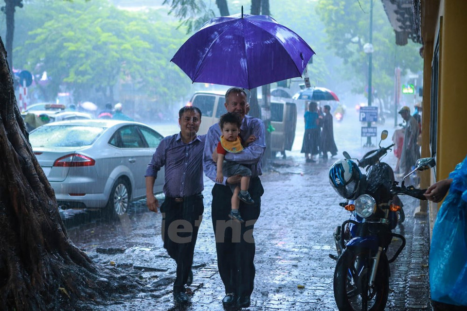 L'ambassadeur des Etats-Unis au Vietnam, Ted Osius, a emmené sa mère, sa sœur et son fils à la pagode Quan Su malgré la pluie. 