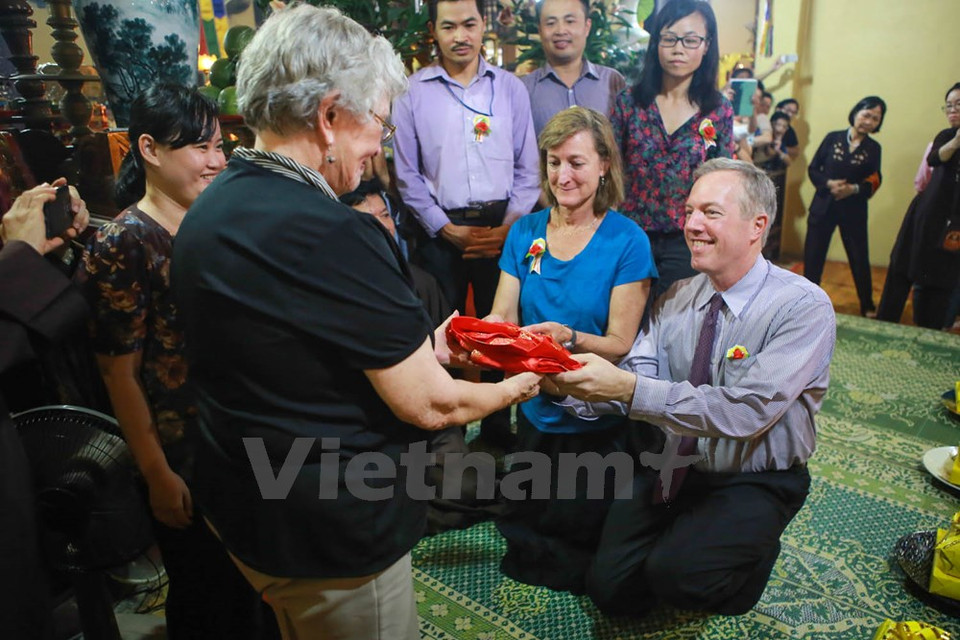 L'ambassadeur et sa sœur offrent une tunique rouge à leur mère pour exprimer leur respect et l​ui souhaiter une longue vie.