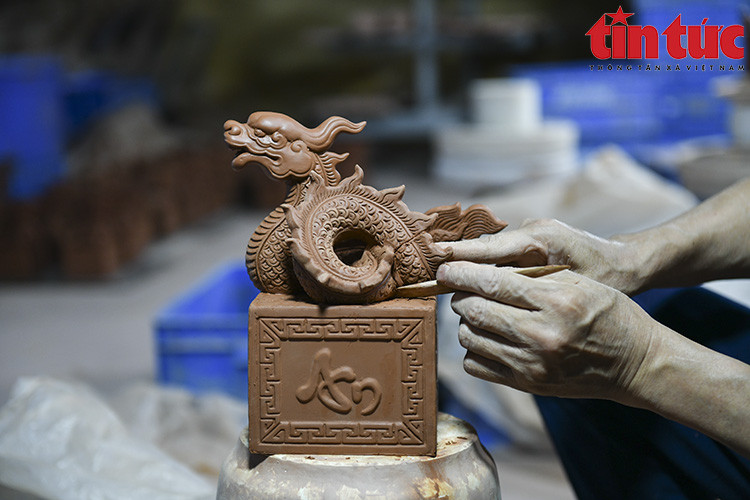 Les artisans du village de céramique de Bat Trang fabriquent des sceaux de dragon plaqués d’or pour le Nouvel An lunaire du Dragon. 
