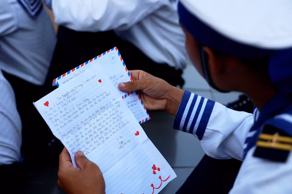 Un soldat de Truong Sa lit attentivement une lettre avec des signes du coeur.