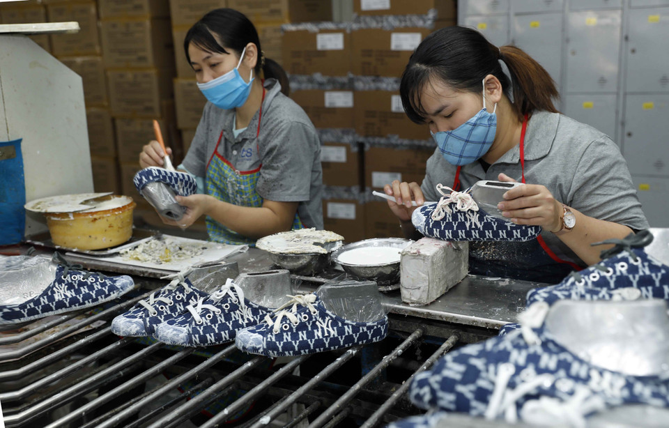 Production de chaussures destinées à l'exportation à la société à responsabilité limitée du tissage chimique d’Ha Tay. Photo : VNA
