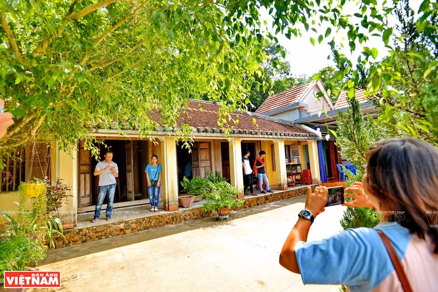 Des touristes visitant une ancienne maison du village. 