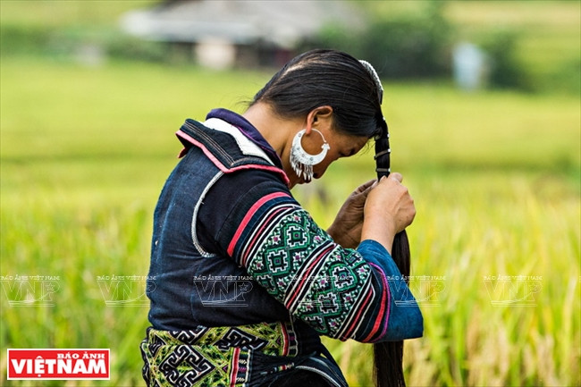 Une femme H’mong (noir) tressant ses cheveux.