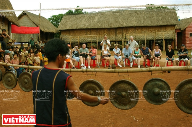  Des touristes écoutent une démonstrations de gongs dans un village.