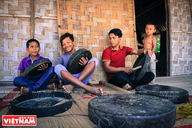 Enfants M’Nông du hameau de Jun apprenant à jouer du gong. 