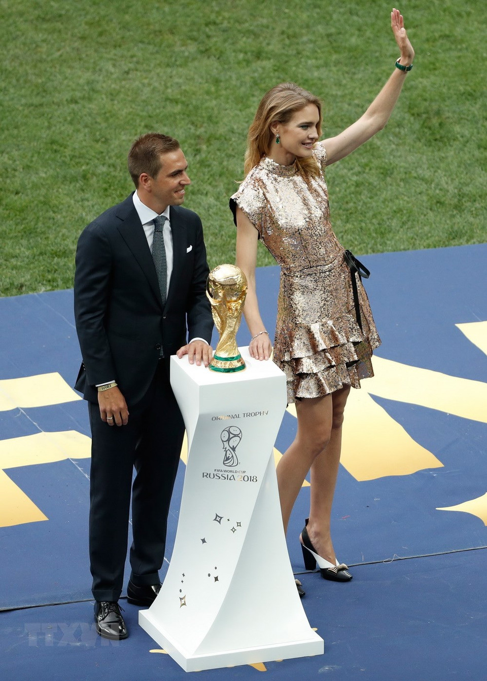  Philipp Lahm, capitaine de l'Allemagne championne du monde en 2014, et Natalia Vodianova, top-modèle russe impliquée dans des initiatives activistes et philanthropiques, apportent le trophée de la Coupe du Monde de la FIFA sur le terrain du stade Loujniki. 