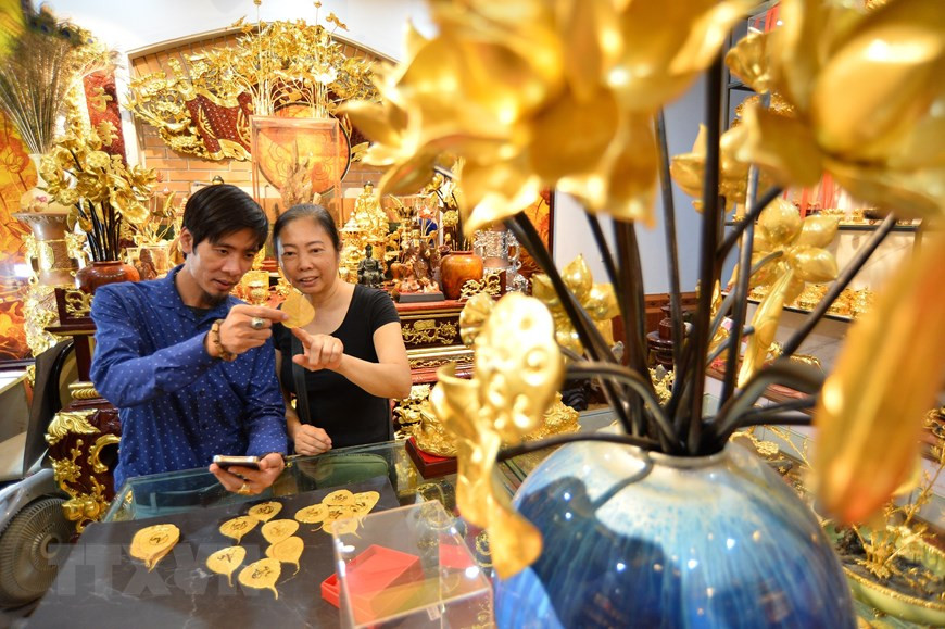  Grâce aux mains talentueuses de l'artisan Nguyen Duc Bang, des feuilles de Bodhi sont plaquées or 24 carats pour devenir des œuvres d'art intemporelles. Photo : VNA