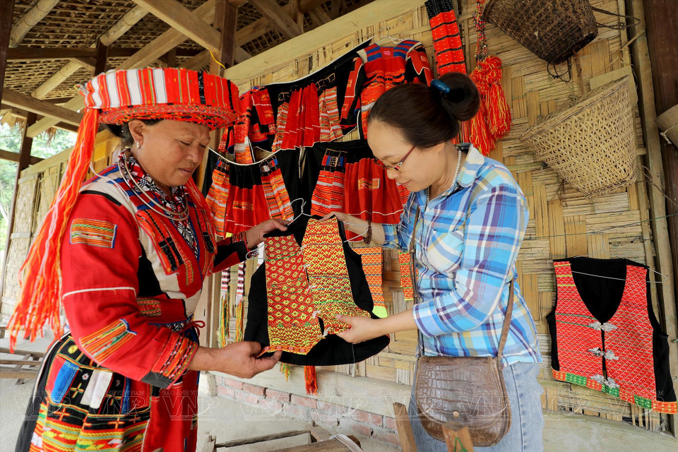  Une visiteuse contemple les vêtements traditionnels des Pa Then.