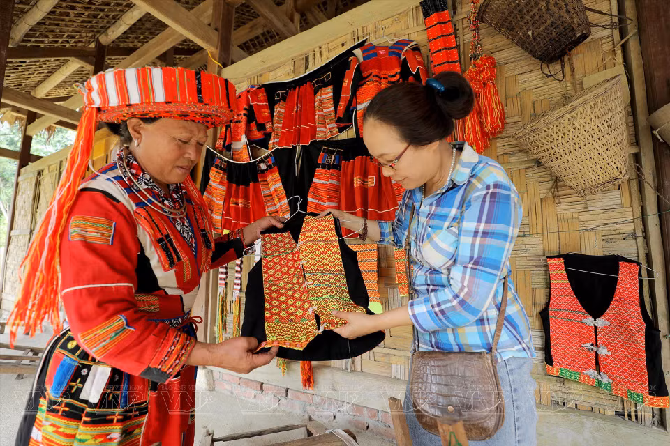  Une visiteuse contemple les vêtements traditionnels des Pa Then. 