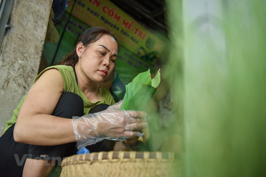  Outre Mê Tri, le côm est également produit dans plusieurs villages en banlieue de Hanoï, dont le village de Vong. Une vieille chanson populaire vante la réputation du côm issu de cette localité : Cốm Vòng, gạo tám Mễ Trì Tương Bần, húng Láng còn gì ngon hơn ? Selon ses explications, la récolte doit se faire dès que les épis de riz commencent à arriver à maturité. Les graines dont l’écorce reste encore verte sont vannées pour éliminer les graines creuses et ne garder que les meilleures. Celles-ci sont lavées et laissées à sécher avant d’être torréfiées dans une poêle en fonte sur un four au charbon de bois pendant environ deux heures. Photo:VietnamPlus