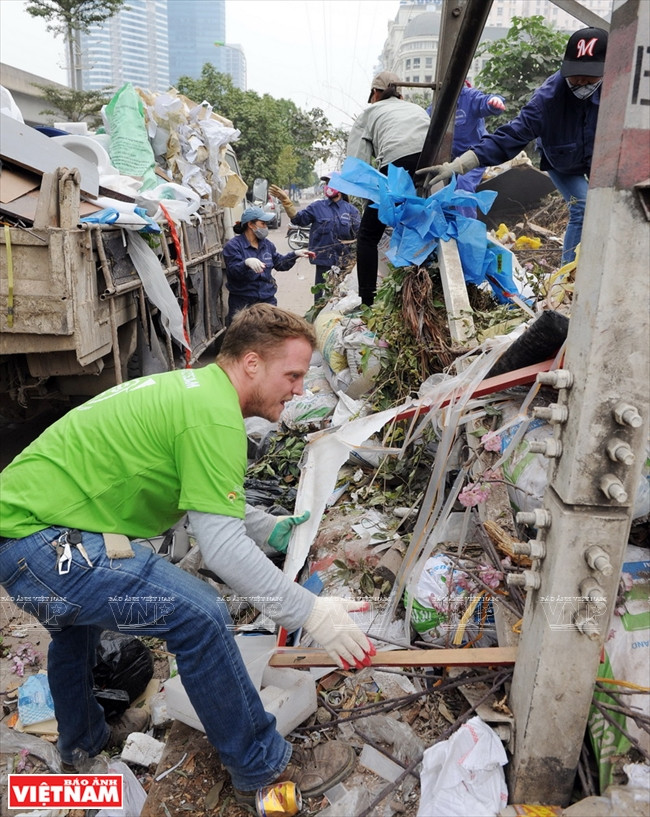 James Joseph Kendall et des membres du Conseil de gestion de projets de Nam Tu Liêm ramassent les déchets dans la rue Pham Van Dông.
