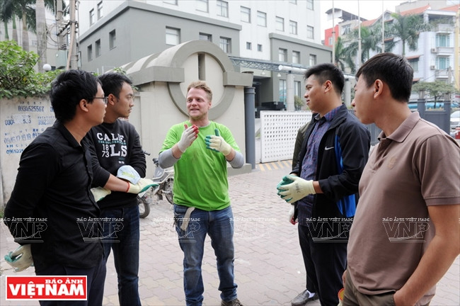 Conversation entre James Joseph Kendall (T-shirt vert) et les membres du Conseil de gestion de projets du district de Nam Tu Liêm en vue du nettoyage de la rue Pham Van Dông.