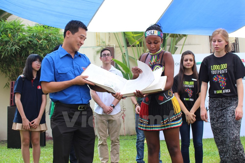 L'ambassadrice sud-africaine de protection des rhinocéros remet un livre sur la protection de ces animaux à un représentant de l'Union de la jeunesse communiste Ho Chi Minh.