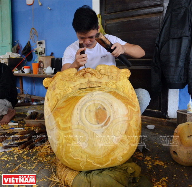 L'artisan grave la cloche. Photo : Thanh Hoà