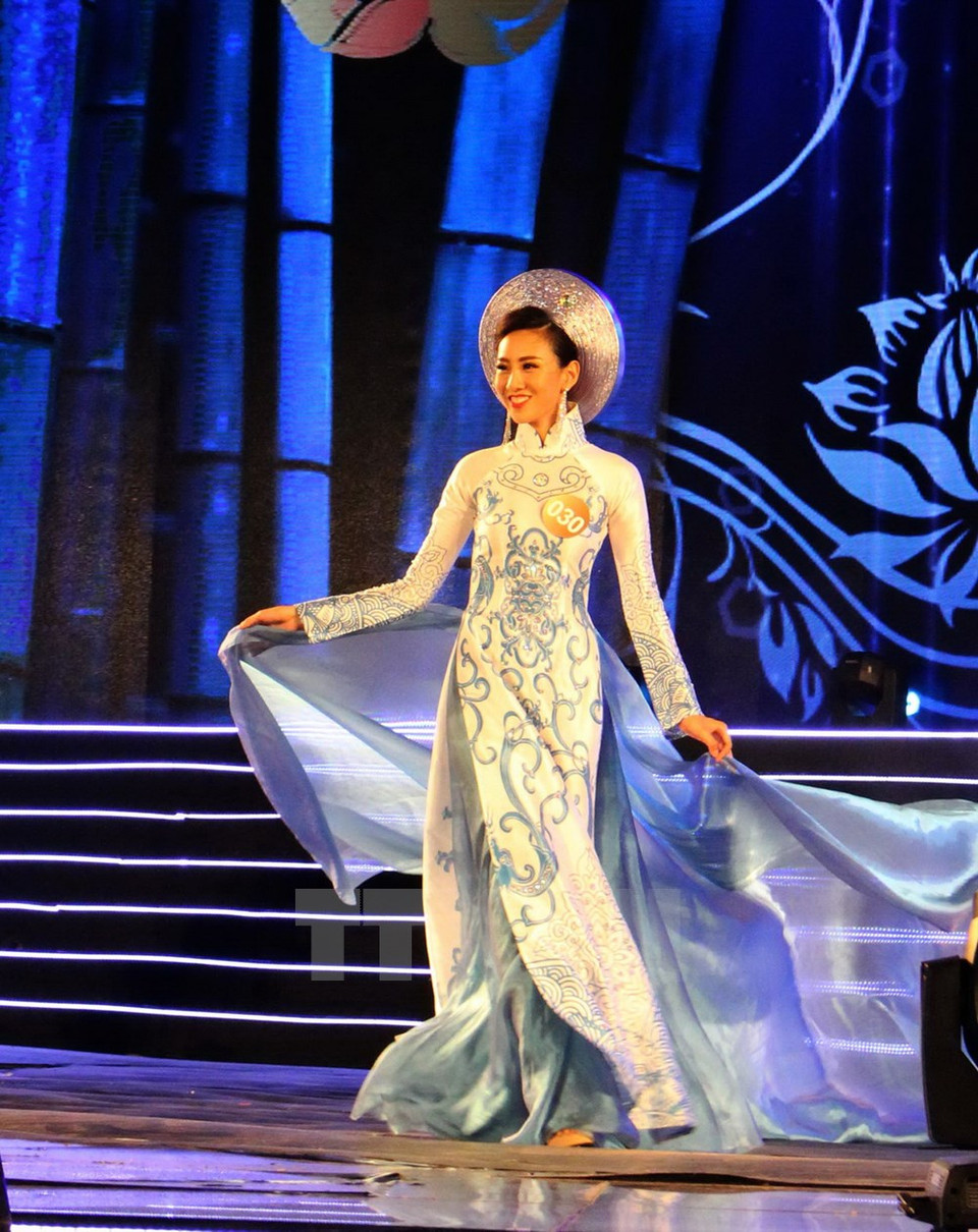  Une candidate en défilé en ao dai (tunique traditionnelle du Vietnam). Photo: VNA