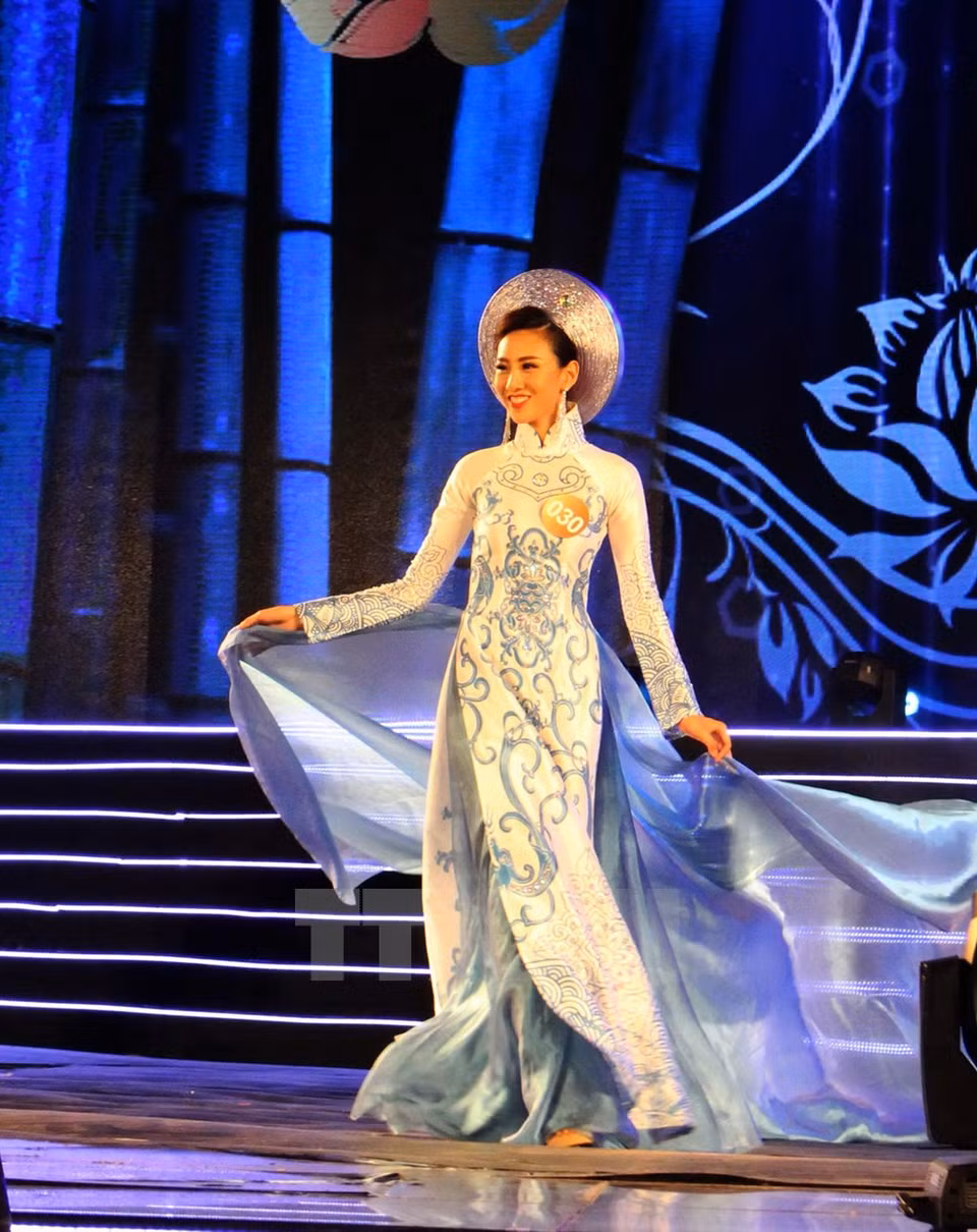  Une candidate en défilé en ao dai (tunique traditionnelle du Vietnam). Photo: VNA