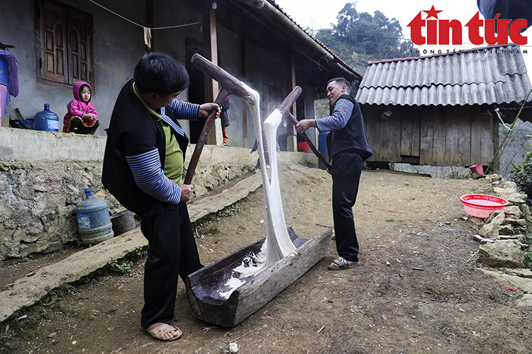 Lorsque le riz est bien cuit, on le met dans une mangeoire en bois et on le pilonne. Photo: VNA