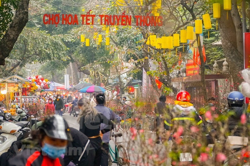 Les petites et moyennes branches de fleurs de pêcher sont un produit typique du marché aux fleurs centenaire. Les commerçants ont acheté les branches de fleurs de pêcher du village de fleurs de Nhat Tan, qui sont considérées comme un symbole du printemps. Les boutons des fleurs de pêcher symbolisent un nouveau départ. Les deux sortes de fleurs largement vendues et achetées pendant le Têt sont "hoa mai" (fleurs d'abricot) et "hoa dao" (fleurs de pêcher). De nos jours, les habitants peuvent réserver des services de livraison pour acheter des fleurs à distance. Cependant, des Hanoiens gardent toujours l'habitude d'aller au marché aux fleurs traditionnel au cœur de la vieille ville pour faire du shopping avec le désir de profiter de l'atmosphère et de la beauté du marché de longue date. C’est une habitude élégante des Hanoiens. Photo: VietnamPlus