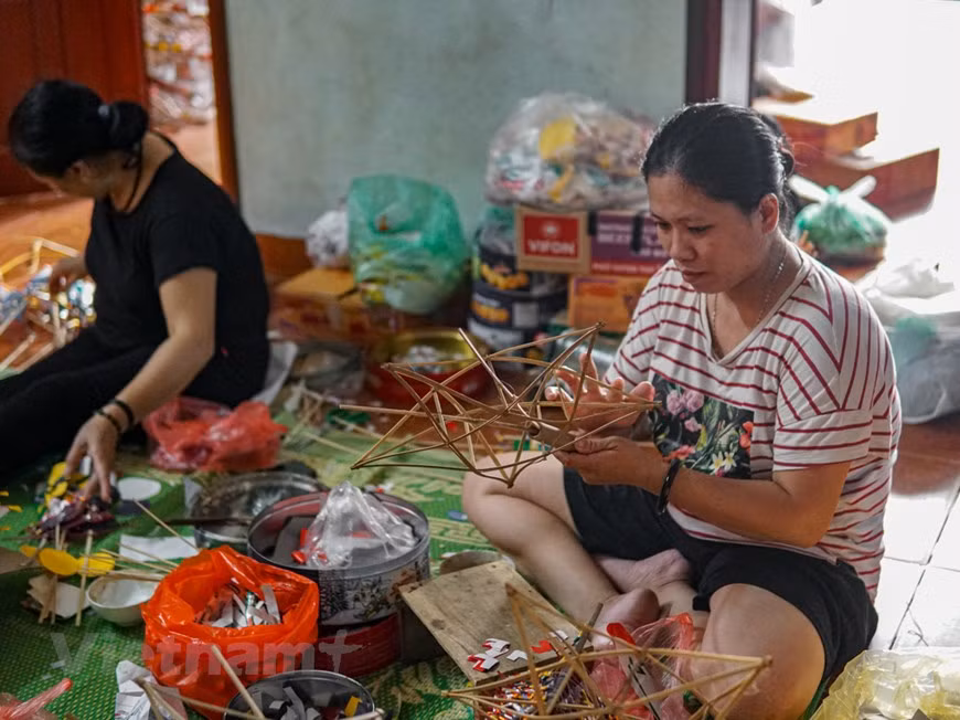 Nguyen Thi Anh, fille de Nguyen Thi Tuyen, et d'autres membres de la famille sont également impliqués dans la fabrication des jouets traditionnels. Selon Nguyen Thi Tuyen, à chaque saison de la Fête de la Mi-automne, sa famille peut produire environ 500 à 700 lanternes de toutes sortes. Chaque produit est vendu à un coût entre 30.000 et 40.000 dong (environ 1,5 dollar américain). "J'espère que les lanternes en forme d'étoile traditionnelles existent toujours dans la mémoire des enfants vietnamiens. Ce sont les enfants qui vont maintenir et de développer cet artisanat, une identité culturelle typique du Vietmam, pour les prochaines générations", a déclaré Nguyen Thi Tuyen. Photo: VietnamPlus