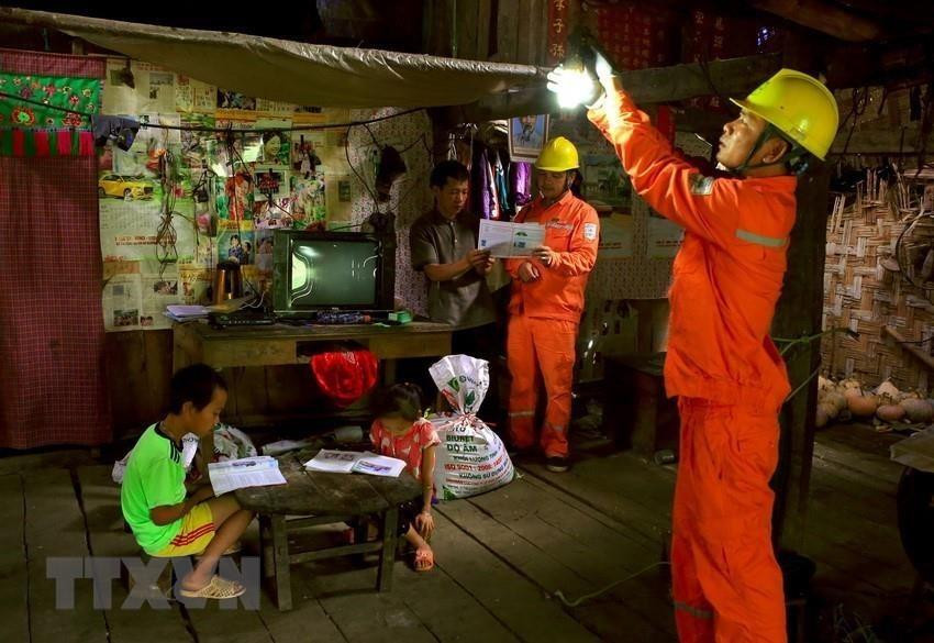 Des ouvriers de la compagnie d'électricité de Cao Bang aide des habitants locaux à utiliser l'électricité de manière efficace et économisée. Photo: VNA