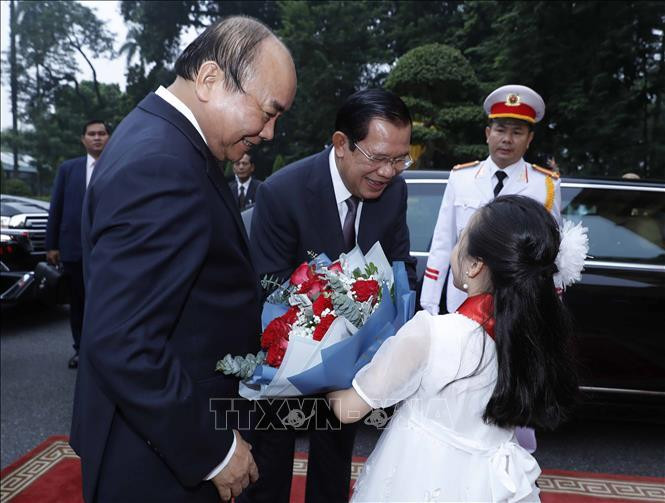 Une petite enfante de Hanoi offre des fleurs au Premier ministre cambodgien Samdech Techo Hun Sen Hun Sen. Photo: VNA 
