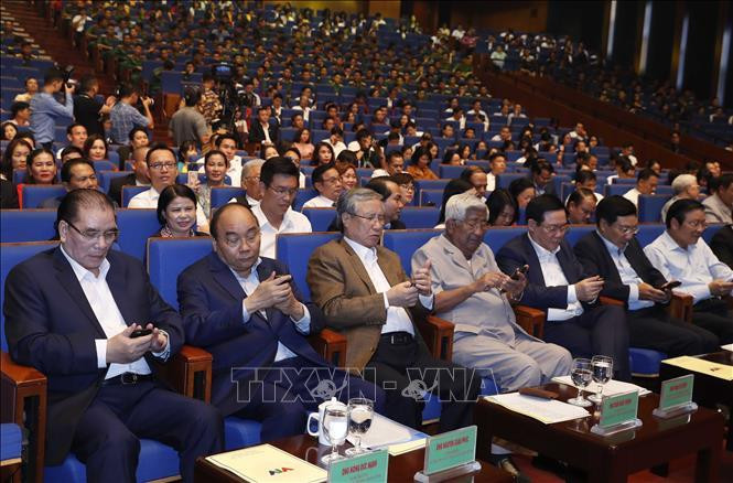 Le Premier ministre Nguyên Xuân Phuc et des délégués envoient des SMS pour soutenir le programme. Photo: VNA