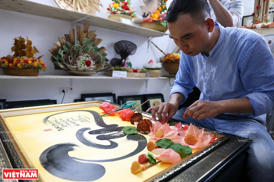 Dung utilise des fleurs séchées pour décorer des peintures et des travaux de calligraphie. Photo: Vietnam Illustré