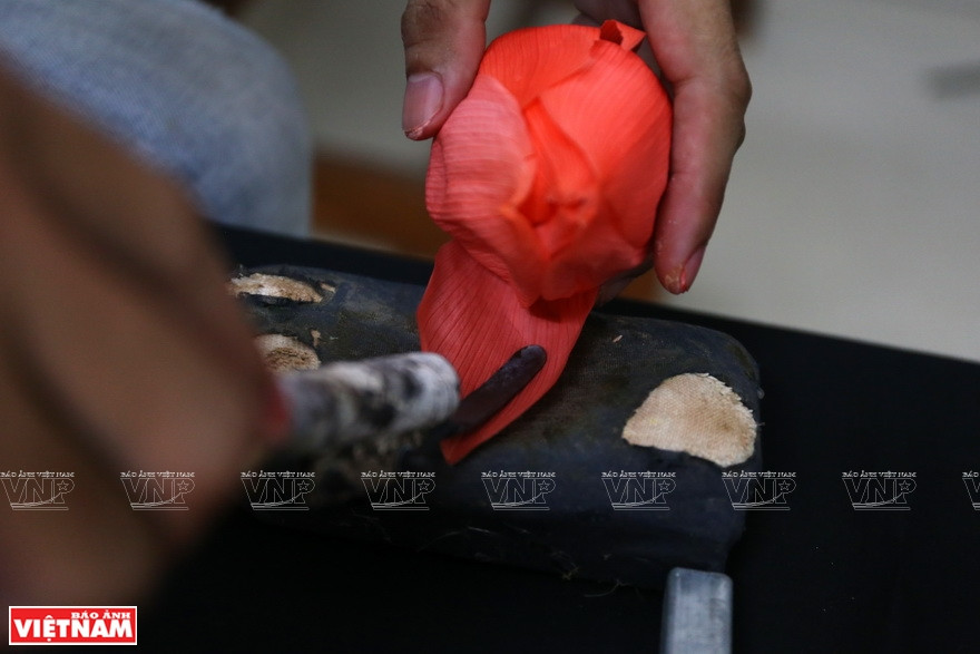 Pour rendre les fleurs douces comme à l'origine, Dung utilise un outil pour aplatir les pétales. Photo: Vietnam Illustré