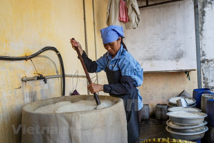 Le riz gluant, après avoir été trempé dans l'eau et bouilli, est étalé sur un plateau en bambou, recouvert de feuilles de longane ou de patate douce.