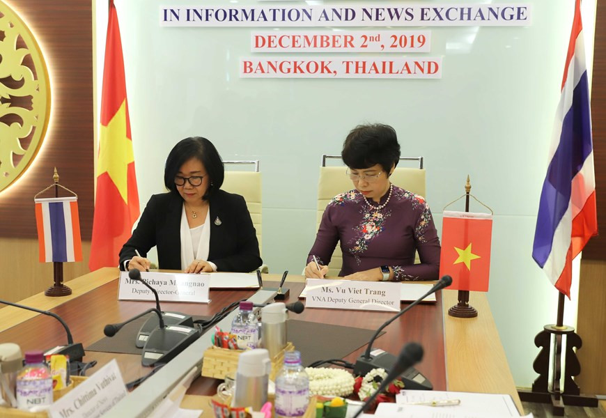 La vice-directrice génrale de la VNA Vu Viet Trang (droite) et la vice-directrice général du PRD Pichaya Muangnao signent l'accord de coopération sur l'information pour l'étranger.