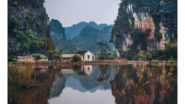 De petites maisons construites au bord d’un lac dans la province de Ninh Binh.