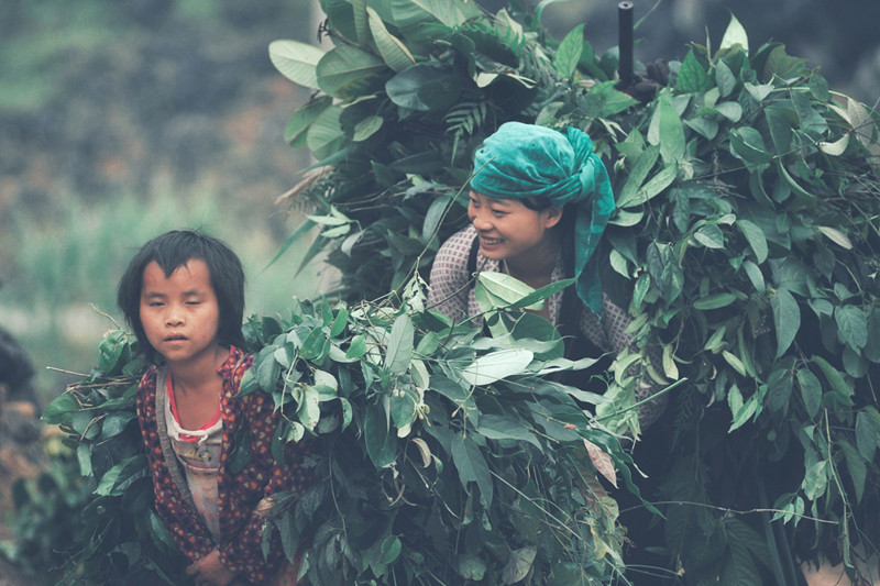 Un garçon suit sa sœur sur le terrain à la jonction de la commune de Duong Thuong, dans le district de Yên Minh.