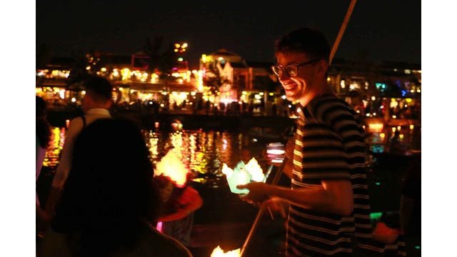 Une touriste étrangère se trouve au bord de la rivière et prend un autoportrait photographique. 