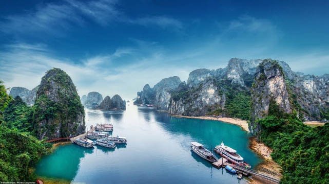 Des bateaux touristiques stationnent au milieu des îlots calcaires en baie de Ha Long (au Nord-Est).
